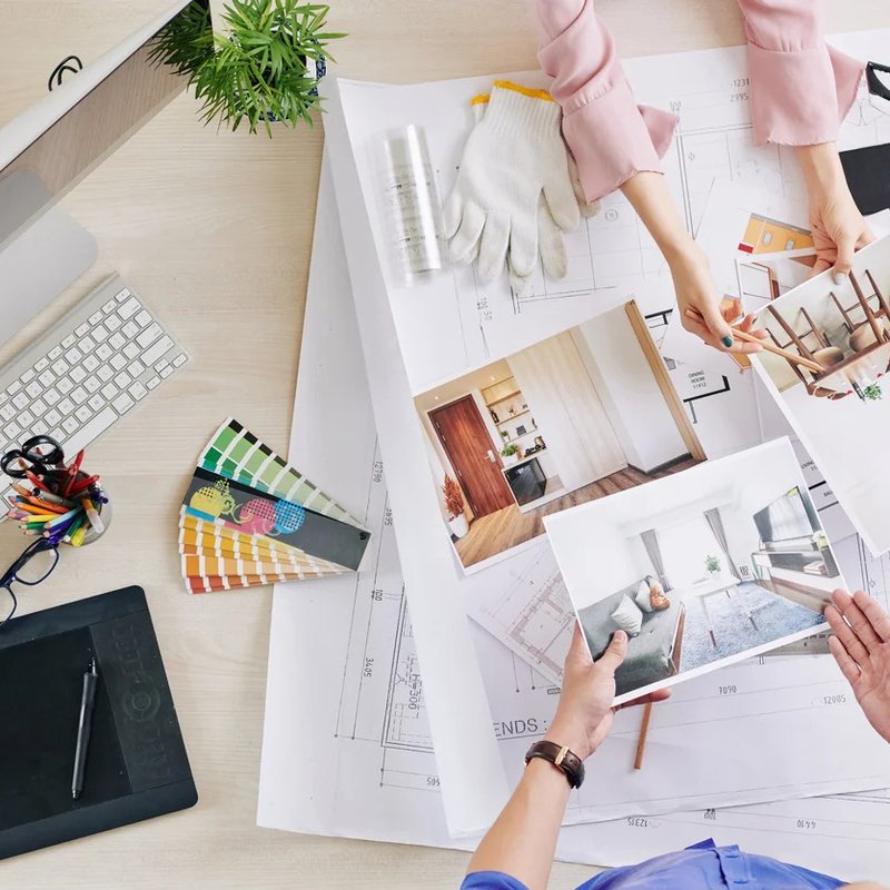 interior design professionals passing plans and photos to each other